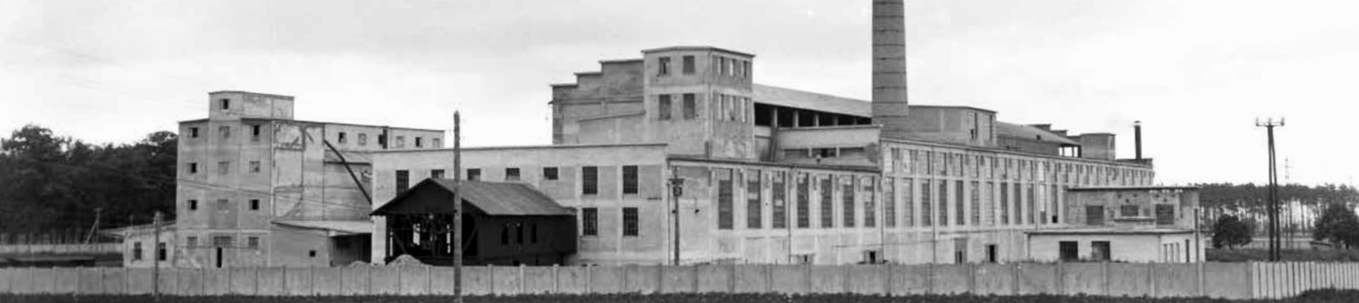 Historic black-and-white panorama of the Stupava cement works with production halls and a chimney